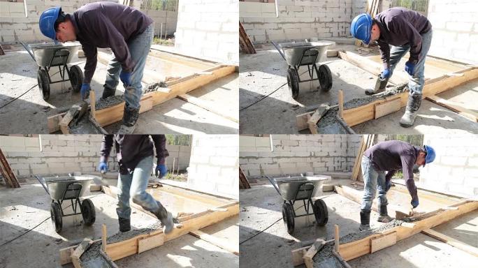 工人在砖石抹子的帮助下将混凝土放入模板中。