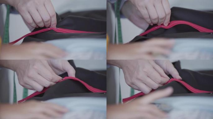 女裁缝的特写手在缝制前用别针将拉链固定在织物上。