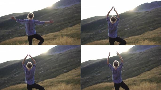 日落时，年轻女子在山顶高高的草丛中自然瑜伽
