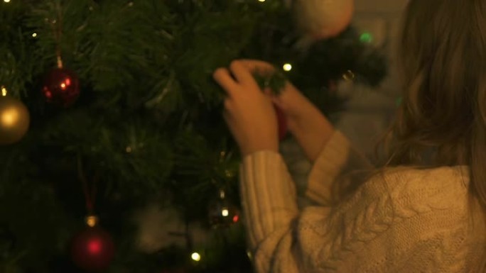 小女孩挂圣诞树玩具，节日装饰，特写