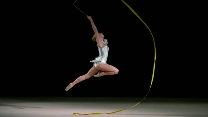 SLO MO艺术体操运动员在跳跃时绕圈挥舞着丝带