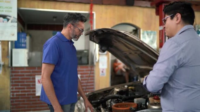 机械师向客户展示汽车修理厂