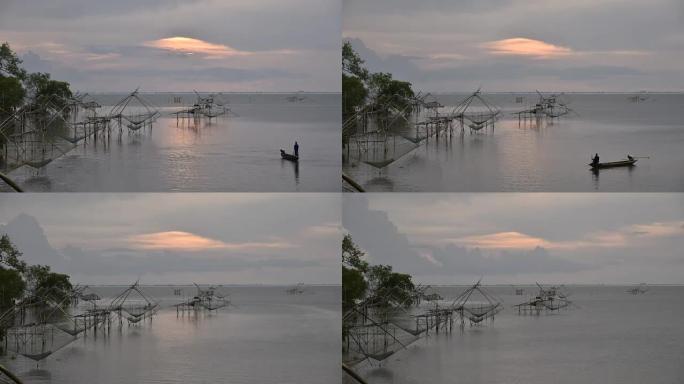 泰国Phatthalung的Park Pra村，宋卡湖的日出，有手工制作的钓鱼陷阱，湖中有一艘木头船