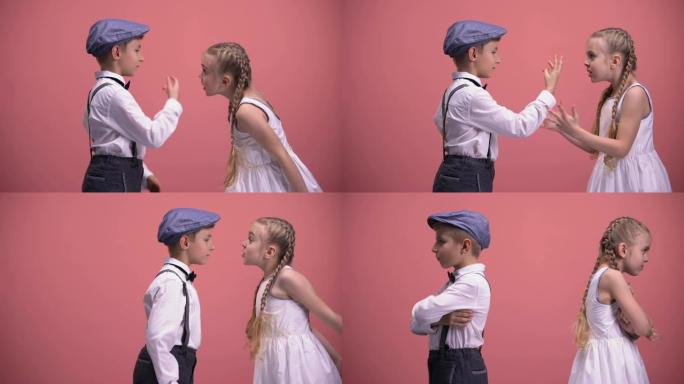 两个小孩情绪激动地打手势和争吵，孤立在粉红色的背景下