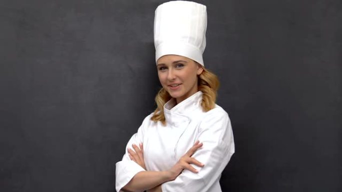 微笑自信的女厨师双手交叉在胸前微笑，职业