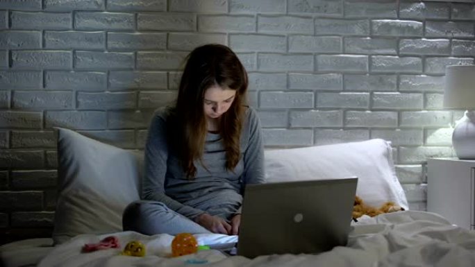 精疲力尽的年轻母亲在笔记本电脑前入睡，缺乏闲暇时间