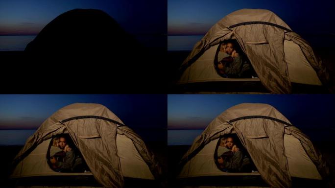 难民儿童坐在帐篷里，躲避岸边的移民边境服务