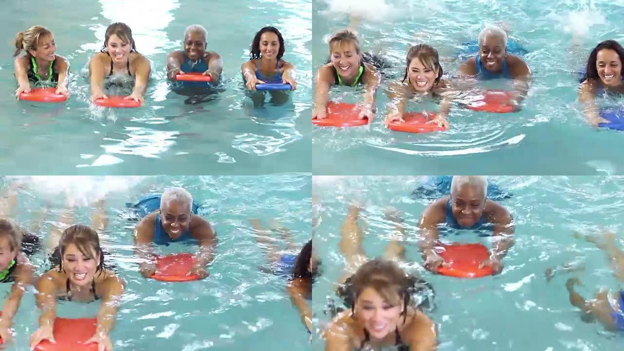 一群多种族妇女用踢脚板游泳