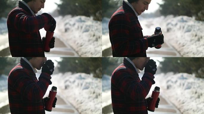 Man pours tea from a thermos winter