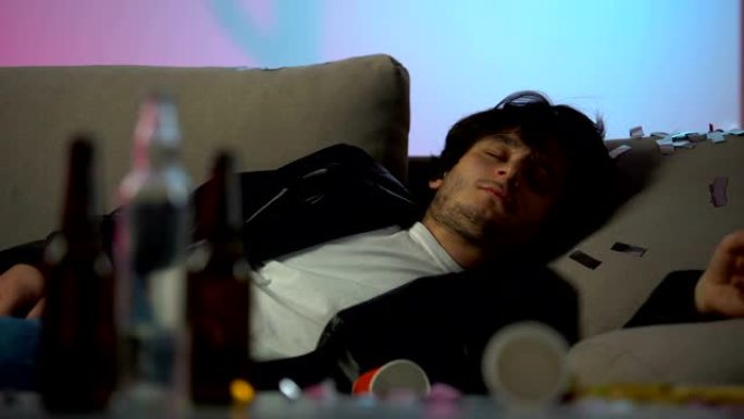 昏昏欲睡的醉汉在家聚会后头痛，桌上空瓶子