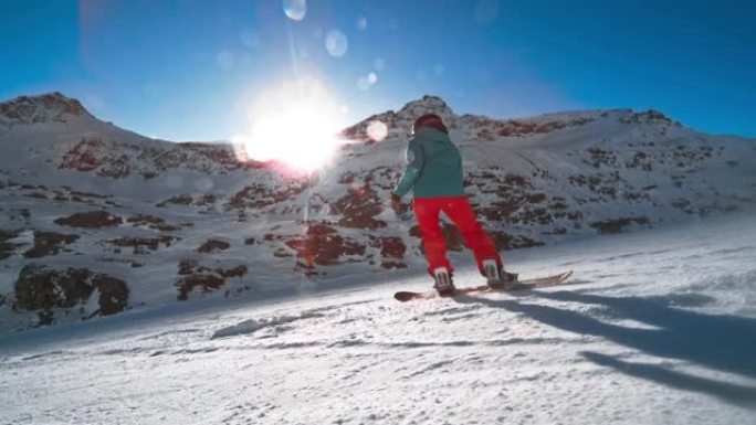 SLO MO TS女滑雪者骑着高山的阳光明媚的山坡