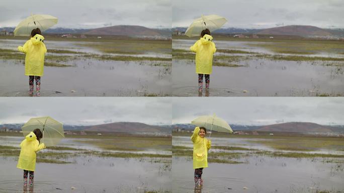 雨中的小女孩儿童戏水踩水雨伞雨衣