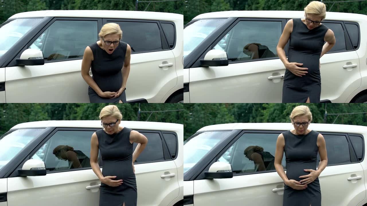 美丽的怀孕上班族走到她的汽车上，感到强烈的胃痛