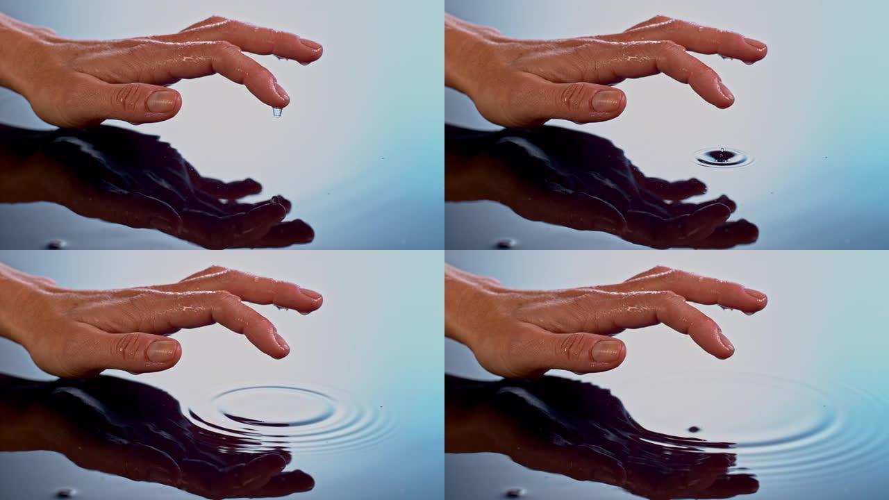 SLO MO水滴从女人的手指掉入水中