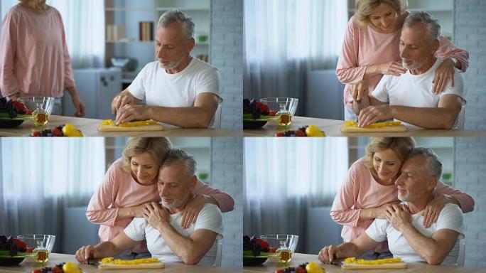 残疾丈夫在厨房做饭，有爱心的妻子拥抱他，支持