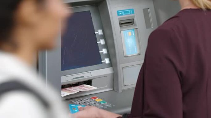 LD女人从自动取款机中取出银行卡并从自动提款机中取钱