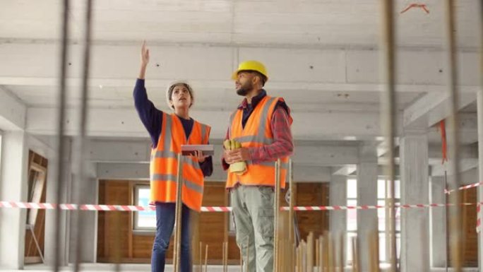 女建筑师与一名男性建筑工人交谈，并解释有关建筑的施工细节