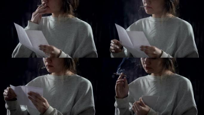 年轻女子带着香烟阅读信，放在信封上，保险