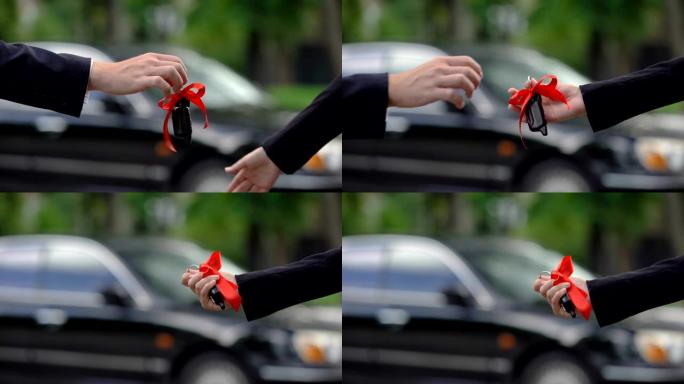 男人把带着大红色蝴蝶结的车钥匙送给女人，令人惊奇的惊喜，珍贵的礼物