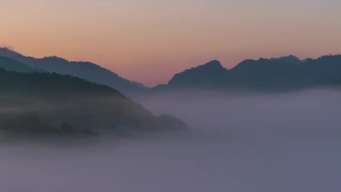 在日出时平移在山谷上流淌的延时雾