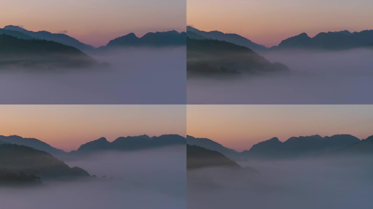 在日出时平移在山谷上流淌的延时雾