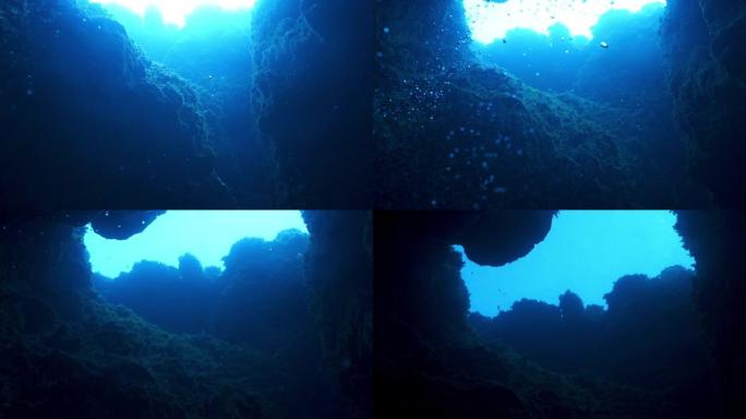慢动作水下射击从海洋洞穴仰望表面