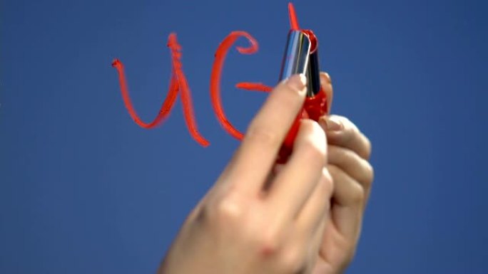 女性用口红手写玻璃上的丑陋单词，自尊问题