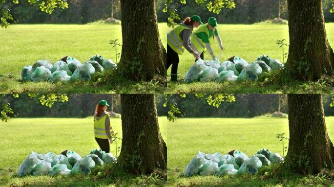 LD当地环保组织的两名年轻妇女在完成清理后将垃圾袋放在一堆上