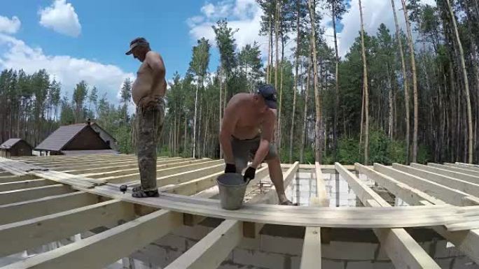 屋顶的建造。建造者将横梁钉在底座上。