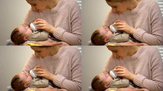 妈妈从瓶子里喂可爱的小宝宝，温柔地和他说话，关心