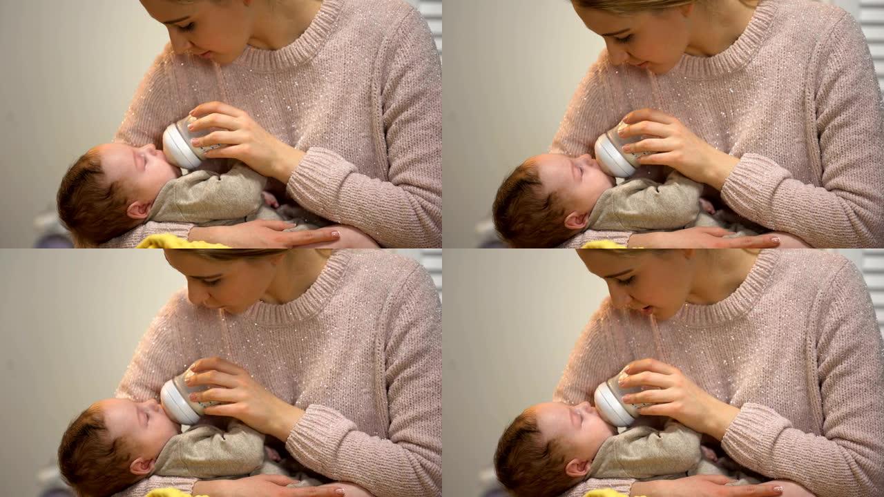 妈妈从瓶子里喂可爱的小宝宝，温柔地和他说话，关心