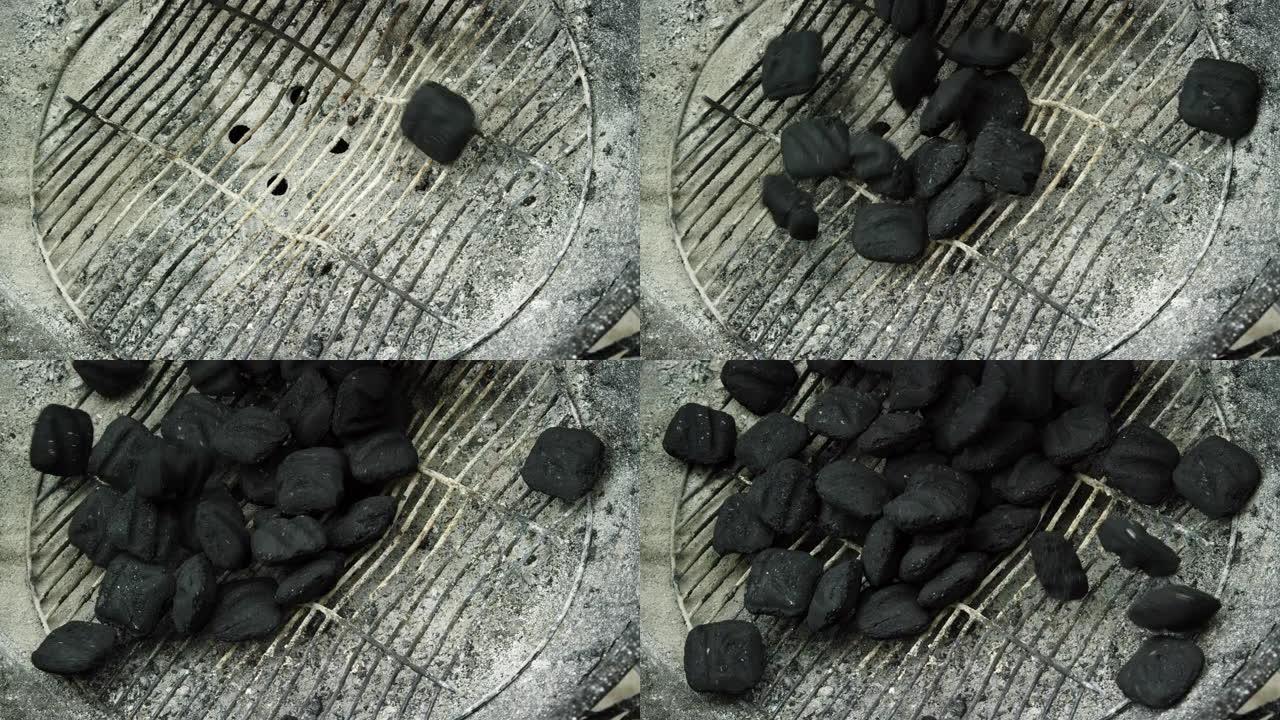 木炭煤块落在户外烧烤架上的金属炉排上，为烧烤做准备