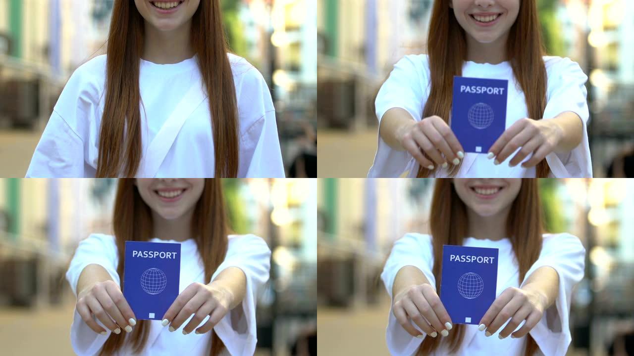 微笑的年轻女子出示蓝色护照，国际旅行证件，旅行