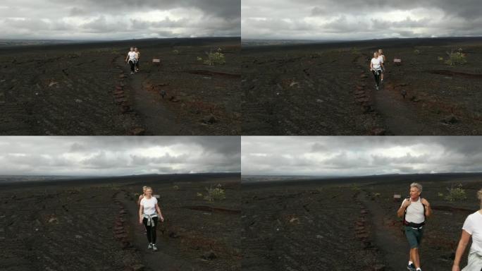 徒步旅行夫妇沿着火山景观的小径前进