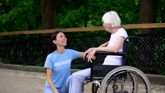 快乐义工听高龄妇女坐轮椅老人关怀