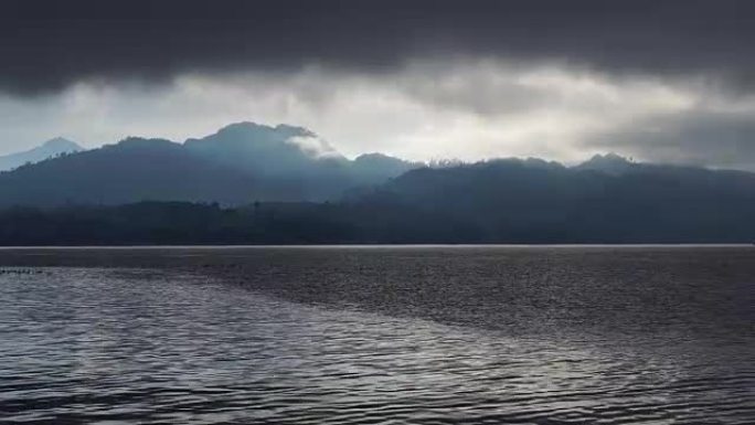 长长的雨云笼罩在山上，风吹过水面