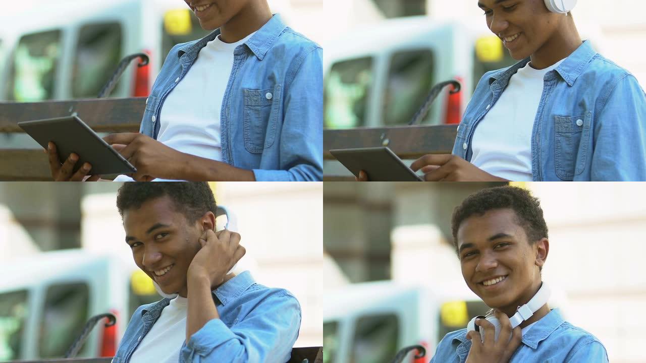 戴着耳机的年轻非洲裔美国少年男孩在平板电脑上混合音乐，混音