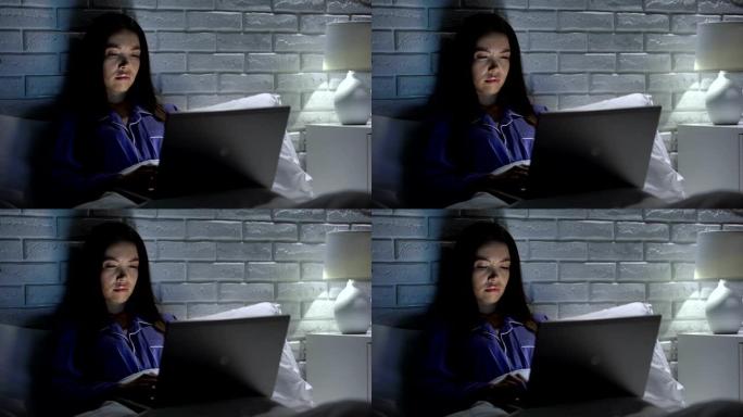 昏昏欲睡的女人晚上在床上用笔记本电脑工作，无聊的项目没有动力