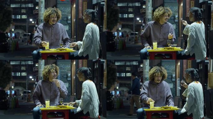 年轻女子在东京的户外餐厅向男友喂食食物