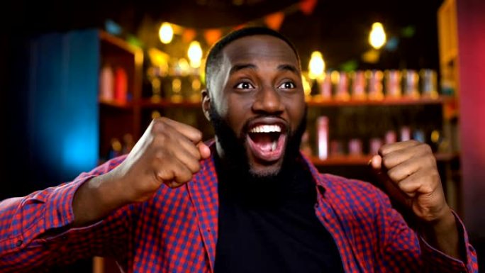 非常高兴的非裔美国球迷在酒吧庆祝最喜欢的球队的胜利