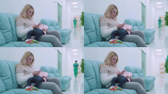 年轻女子坐在医院舒适的沙发上，婴儿在怀里睡觉