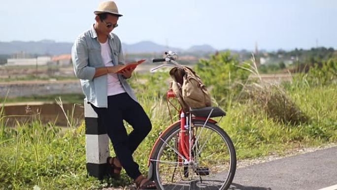 时髦的人带着老式自行车从旧的旅行书籍中旅行