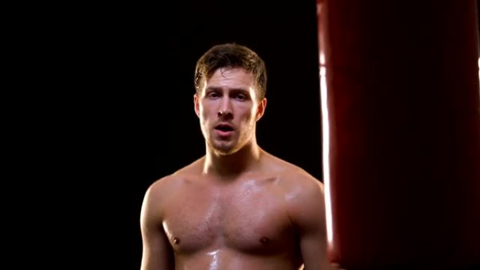 体育男子在筋疲力尽的拳击训练后挥汗如雨，成功和动力