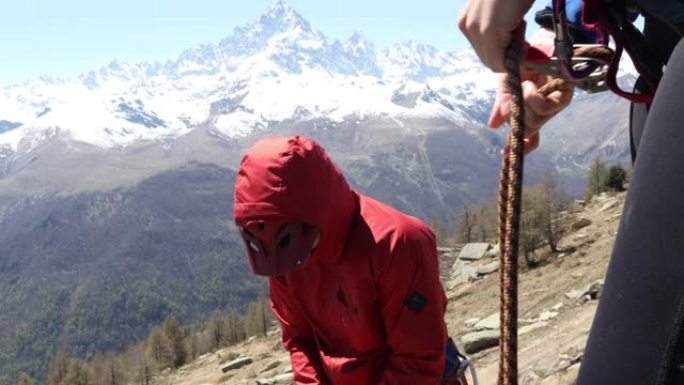 山地车手准备在垂直悬崖上猛拉 (abseil)