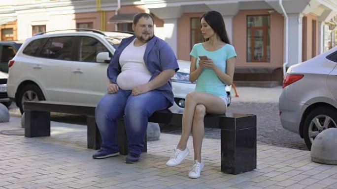 苗条的女人忽略了超重的男人，社会排斥，肥胖损害了健康