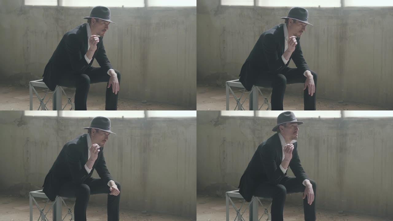 肖像英俊自信的男人戴着一顶帽子，把坐在一个废弃的建筑里的硬币抛起来，接住了。