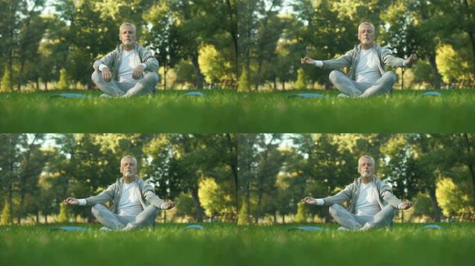 健康的老人在公园冥想，坐莲花在瑜伽垫上，禅