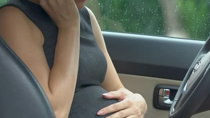 受惊的孕妇女商人打电话给911，坐在车里，早产