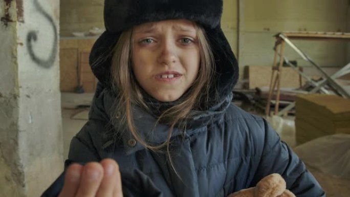 穿着脏冬衣的叙利亚小难民在乞求施舍