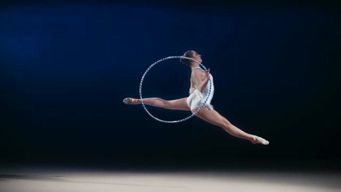 SLO MO SPEED RAMP LD艺术体操运动员在跳跃过程中绕着她的手旋转箍